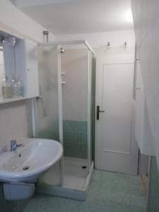 een witte badkamer met een douche en een wastafel bij Casa vacanze Maria Chiara in San Benedetto del Tronto