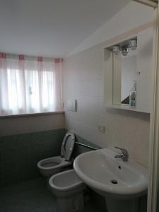 een badkamer met een wastafel, een toilet en een spiegel bij Casa vacanze Maria Chiara in San Benedetto del Tronto