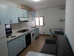 een keuken met witte kasten en een fornuis met oven bij Casa vacanze Maria Chiara in San Benedetto del Tronto