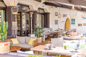 un patio con divani e tavoli in un ristorante di Single Fin Hotel & Lodge a Mimizan-Plage