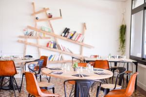 a row of tables and chairs in a room at Single Fin Hotel & Lodge in Mimizan-Plage