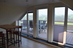 a balcony with a table and chairs and windows at Altes Haus in Sevenig