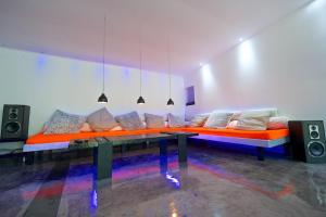 a living room with an orange couch and speakers at La grange des Palles in Vijon