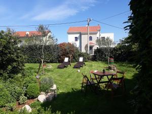 a garden with a table and chairs and a building at House Villa Mare in Malinska