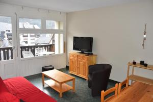 a living room with a couch and a tv at La montagne d'aure in Saint-Lary-Soulan