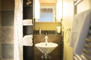 a bathroom with a sink and a mirror and towels at Hotel Alter Hafenspeicher in Stralsund