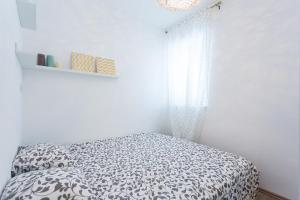a white bedroom with a bed and a window at Apartment Lea Old Town in Poreč