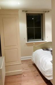 1 dormitorio con cama y ventana en Apartment 2 Oakleigh House, en Cork