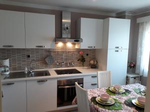 a kitchen with white cabinets and a table with chairs at House Villa Mare in Malinska