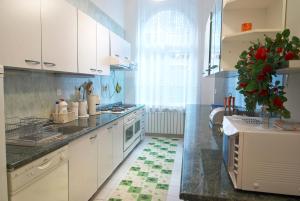 a kitchen with white cabinets and a plant on the counter at Hostel Residence in Sarajevo