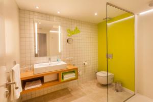 a bathroom with a sink and a toilet and a mirror at Vanilla Garden Boutique Hotel - Adults Only in Playa de las Americas