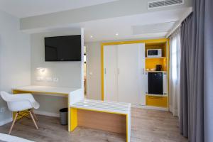 a small apartment with a desk and a tv at Vanilla Garden Boutique Hotel - Adults Only in Playa de las Americas