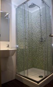 a shower with a glass door next to a sink at Cloud 9 Hostel in Lagos