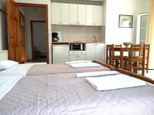 a bedroom with two beds and a kitchen at Studios Evgenia Parga in Parga