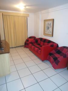 a living room with a red couch and a white tile floor at Porto de Iracema Vista Mar in Fortaleza