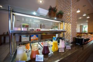 a counter with many different types of drinks in jars at Hotel Metropolitano in Coronel Fabriciano