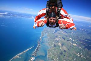 two people are flying over the water at Almyra Waterfront Accommodation in Tasman