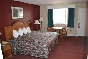 a hotel room with a bed and a table at Seabrook Inn in Seabrook