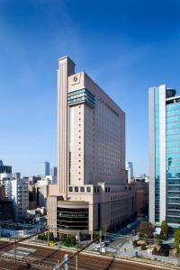 a large building with a clock on it in a city at Dai-ichi Hotel Tokyo in Tokyo