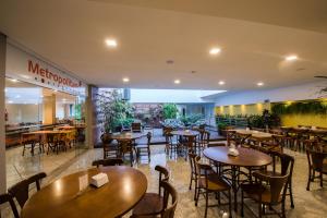a restaurant with wooden tables and chairs in a building at Hotel Metropolitano in Coronel Fabriciano