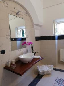 baño con lavabo y espejo en Agorà Suites & Apartments, en Manduria