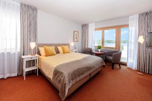 a bedroom with a large bed and a large window at Wittlers Hotel in Ratzeburg