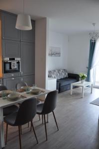 a living room with a table and chairs and a couch at Apartament Zielone Tarasy in Olsztyn