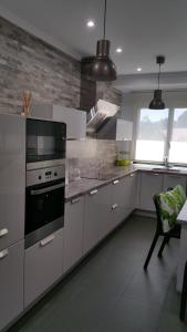 cocina con armarios blancos y fogones en Apartamento ideal Familias y Grupos, en Vigo