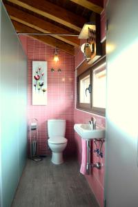 a pink bathroom with a toilet and a sink at El Carmen Fresa in Marlín