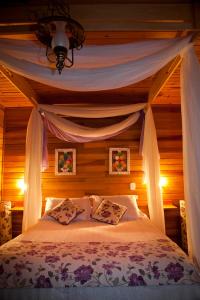 a bedroom with a bed with a canopy at Pousada Oliveri in Monte Verde