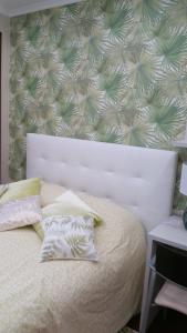 Un dormitorio con una cama blanca con una pared verde y blanca en Apartamento ideal Familias y Grupos, en Vigo