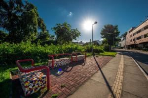 a row of park benches on a sidewalk with a street light at Hotel Metropolitano in Coronel Fabriciano