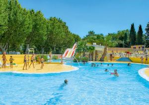 un grupo de personas en una piscina en un parque acuático en Mobilhome Climatisé 3CH 6P dans Parc des 7 Fonts en Agde