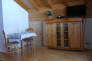 a living room with a table and a tv on a cabinet at Haus Wiesenruh in Oberstdorf