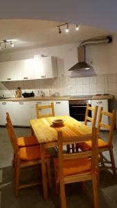 a wooden table and chairs in a kitchen at Beach House Bassi in Rijeka