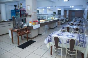 a restaurant with tables and chairs in a kitchen at Hotel Serrador in Passo Fundo