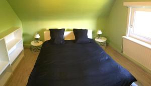a bedroom with a bed with blue sheets and two lamps at Maison du golf in Nieuwpoort