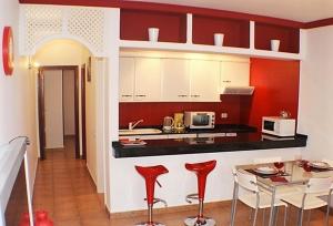 ティアスにあるApartamentos JANESKAのキッチン(赤と白のキャビネット、テーブル付)