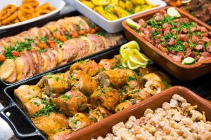 a buffet of different types of food in trays at Hotel Metropolitano in Coronel Fabriciano