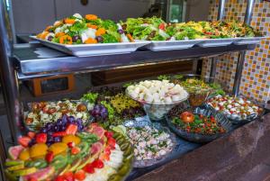 a buffet filled with lots of different types of food at Hotel Metropolitano in Coronel Fabriciano