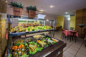 a restaurant with a display of vegetables and fruits at Hotel Metropolitano in Coronel Fabriciano