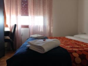 2 toallas encima de una cama en una habitación en B&B Colombo, en Pisa