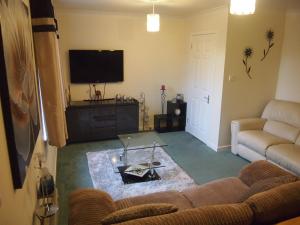 a living room with a couch and a tv at Craignay Guest House in Inverness