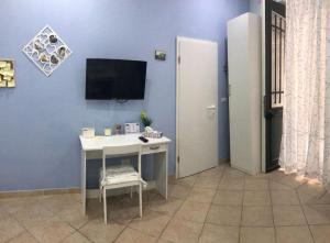 シラクーサにあるCasa Elenaの青い壁にテレビとデスクが備わる客室です。