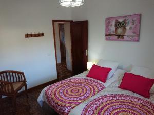 ビラフロールにあるEl Jardín de las Retamasのベッドルーム1室(大型ベッド1台、赤い枕付)