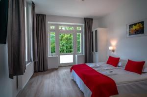 a hotel room with two beds and a window at Willa Tęcza in Szczawnica