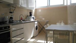 a kitchen with a sink and a table with chairs at Simoes de Castro Flat in Coimbra