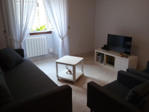 uma sala de estar com um sofá, uma televisão e uma mesa em Casa Do Zoqueiro em Arzúa