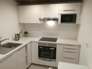 a kitchen with white cabinets and a stove top oven at Apartment Cosmelux Nürnberg in Nuremberg