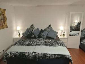 ein Schlafzimmer mit einem großen Bett mit blauen Kissen in der Unterkunft Apartment Cosmelux Nürnberg in Nürnberg